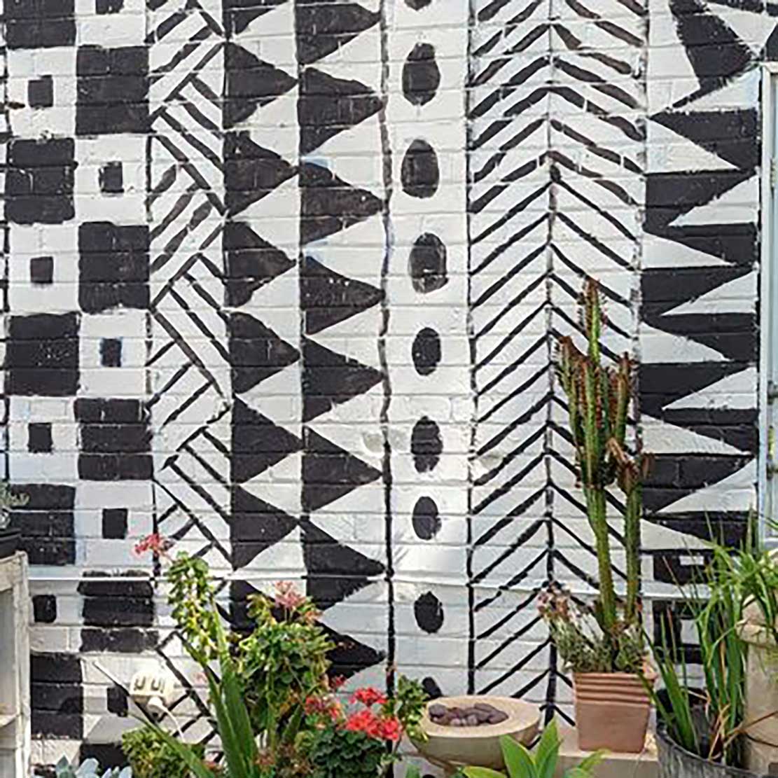 a mural on a wall at the art garden painted in simple black and white patterns
