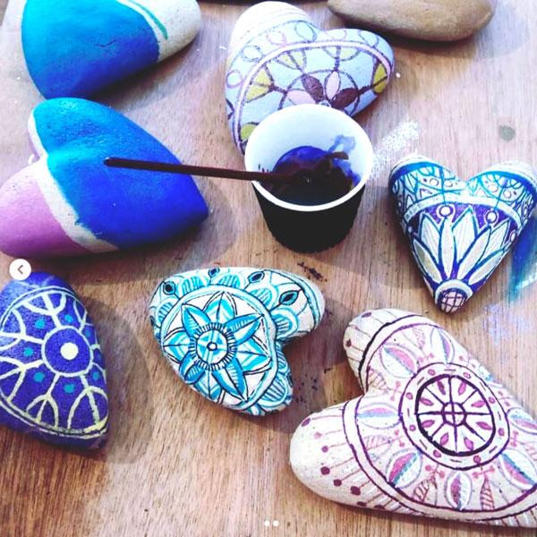 stone hearts being painted and patterned with acrylic paint