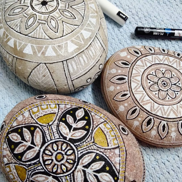 some rocks in the process of being patterned with mandalas