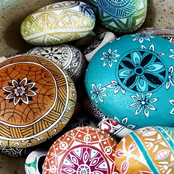 a collection of beautiful patterned mandala rocks