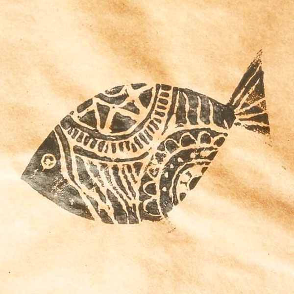 a closeup of the gray fish stamped onto brown paper