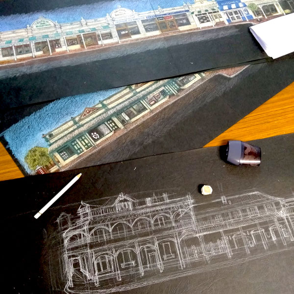 a progress photograph of Mandy drawing historical York buildings - half way through